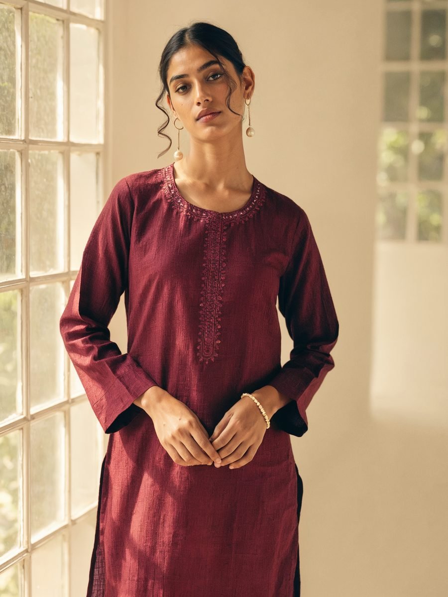 Model wearing a long straight-cut maroon kurti